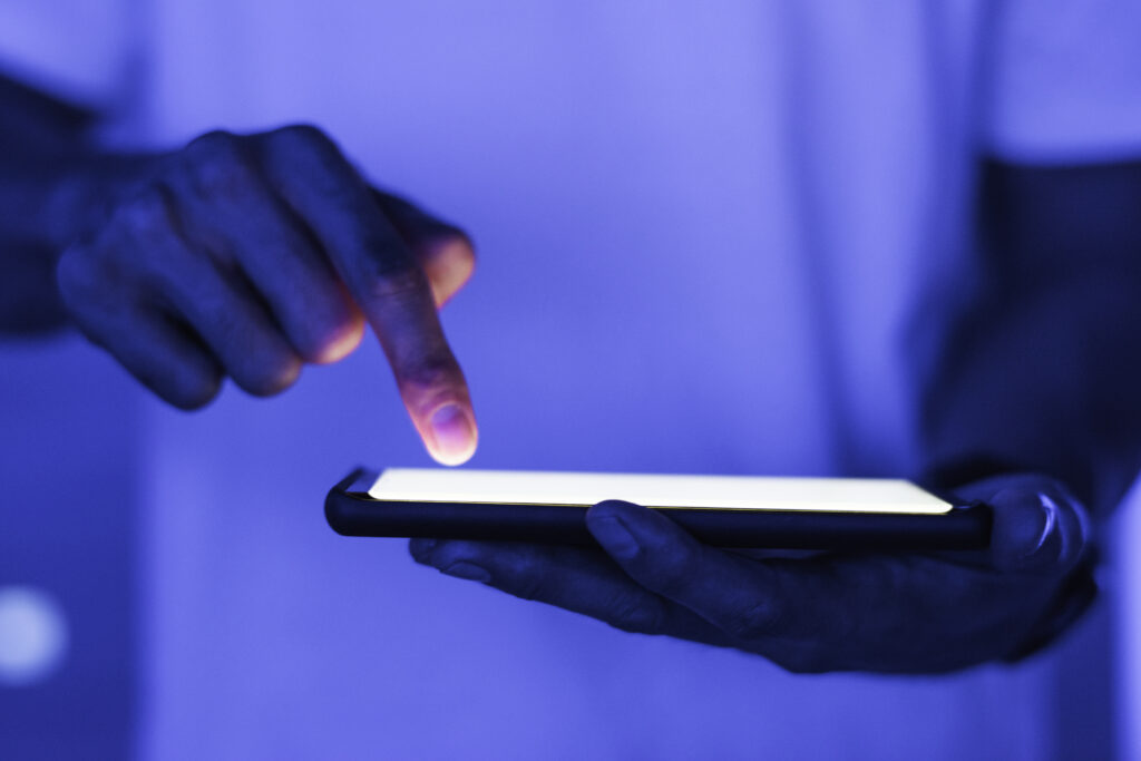 un smartphone à écran tactile éclairé, dans une ambiance bleutée.